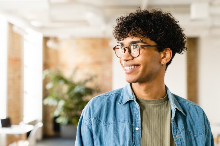 Smiling handsome african-american young man guy freelancer student manager it worker designer in smart casual working studding in the modern office loft coworking cafe.